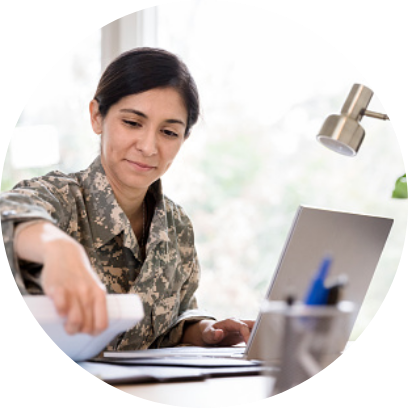A woman in army attire working at a desk